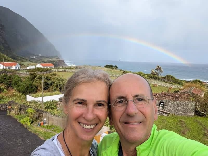 The hosts on the coast at Fajã Grande, a rainbow over the sea behind them