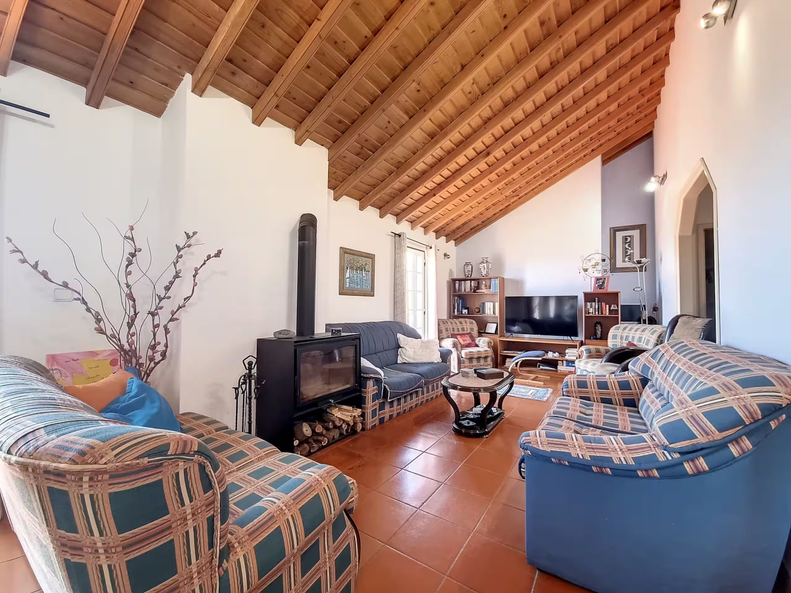 Living room 2 upstairs, with the wood-burning fireplace, sofas and TV under the beamed ceiling